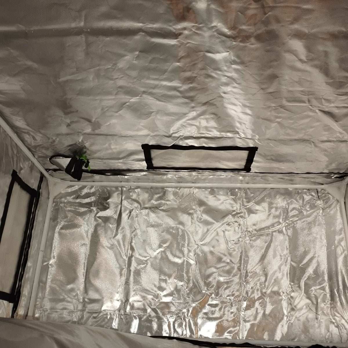 Base intérieure de la tente Guerilla Box, montrant la surface au sol recouverte de toile mylar réfléchissante et les sorties d’air.