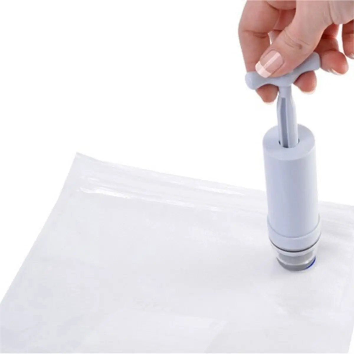 Une pompe sous vide manuelle en pleine utilisation sur un sac.